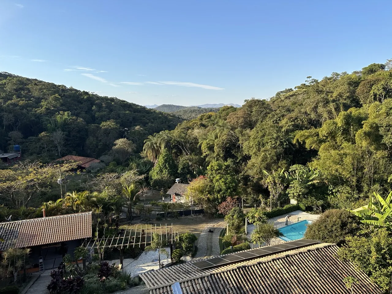 Vista aérea do sítio, com a piscina e a serra ao fundo